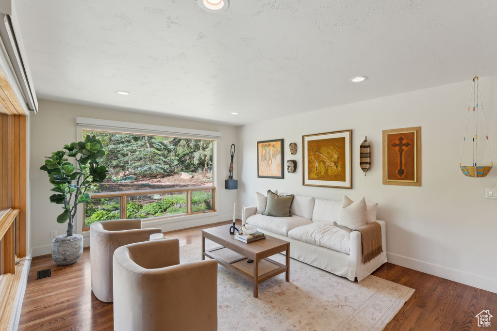 Living room with baseboards, wood finished floors, and recessed lighting