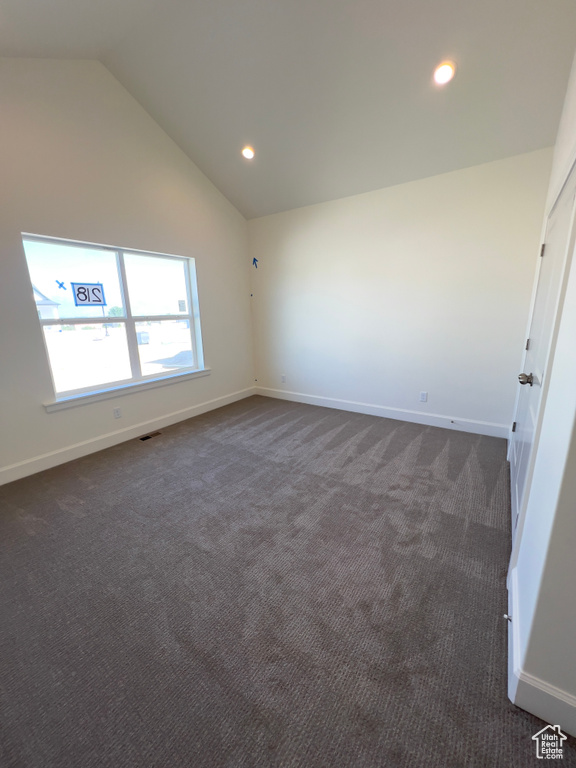 Unfurnished room with lofted ceiling, dark colored carpet, recessed lighting, and baseboards