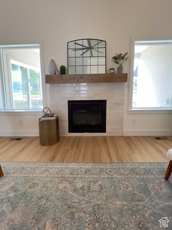 Detailed view of wood finished floors, a tile fireplace, and baseboards