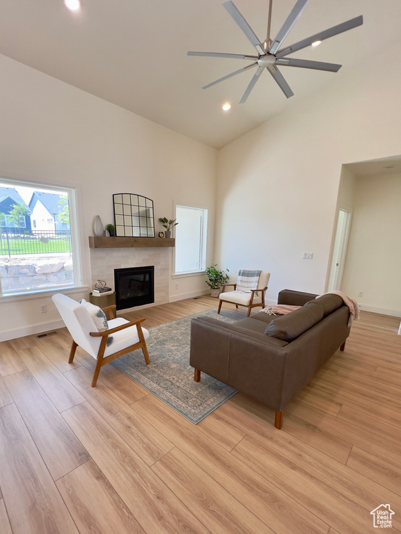 Living area with light wood-style floors, a tile fireplace, recessed lighting, a ceiling fan, and baseboards
