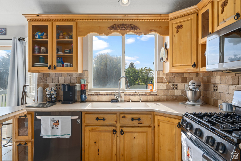 Kitchen with appliances with stainless steel finishes, sink, and backsplash