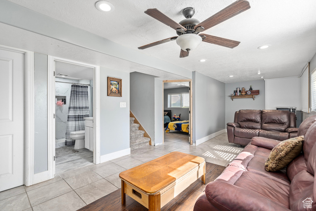 Living room featuring ceiling fan, a textured ceiling, plenty of natural light, and light hardwood / wood-style floors