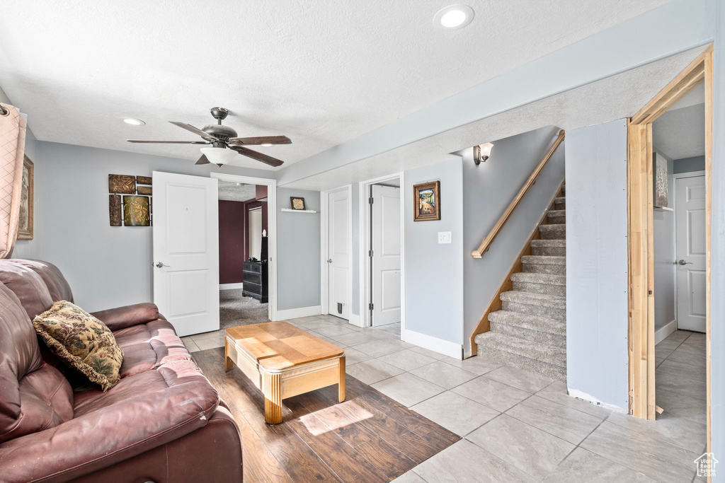 Living room featuring ceiling fan and a textured ceiling