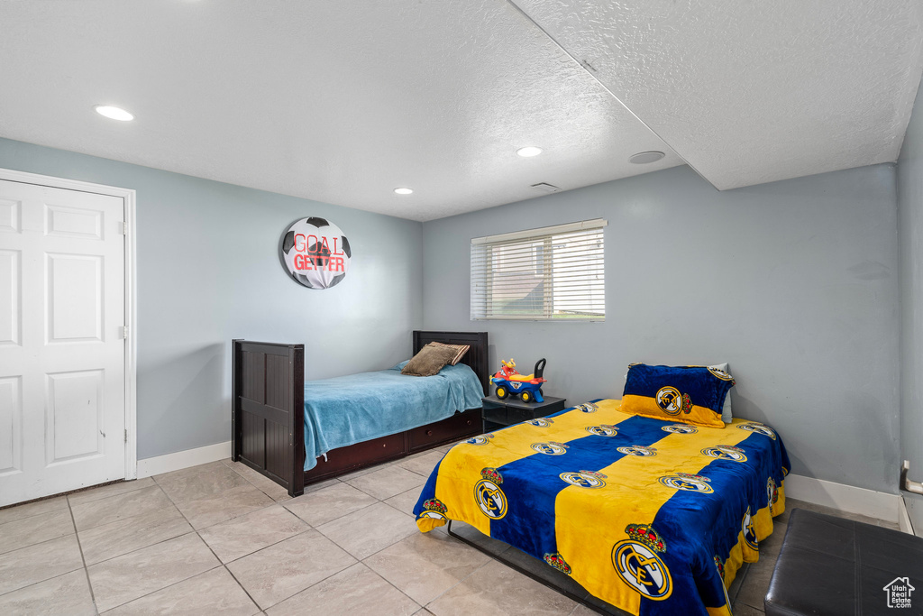 Tiled bedroom with a textured ceiling