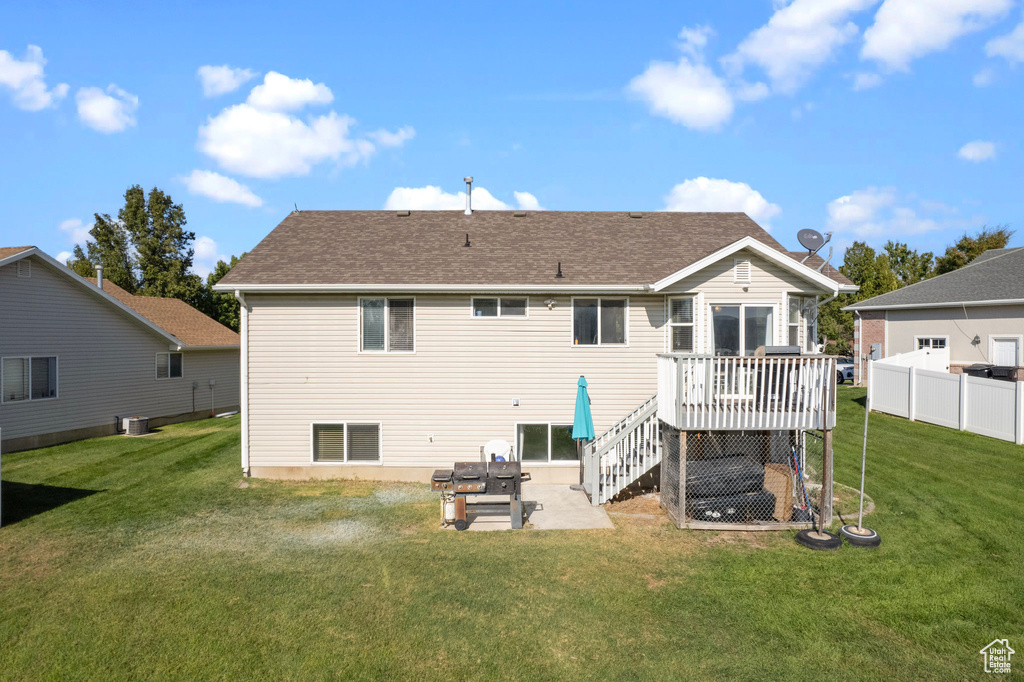 Rear view of house with a wooden deck, a yard, and a patio area