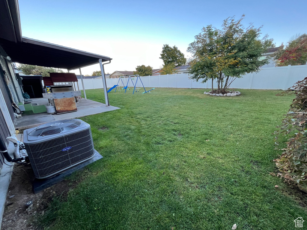 View of yard with central air condition unit and a playground