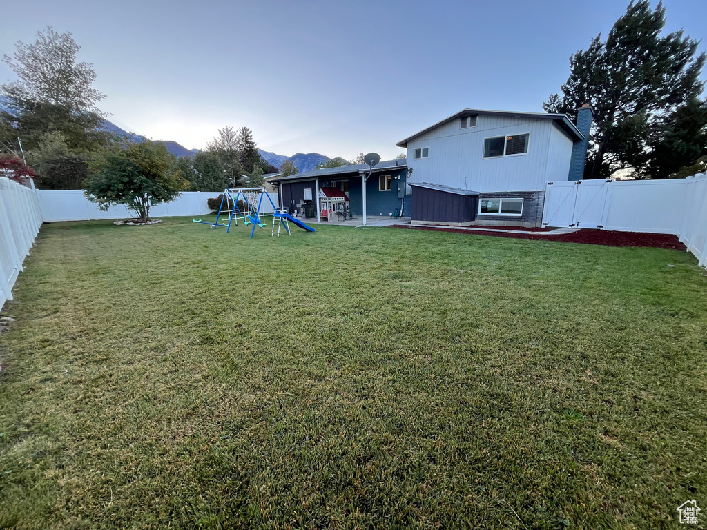 View of yard with a mountain view, a patio area, and a playground