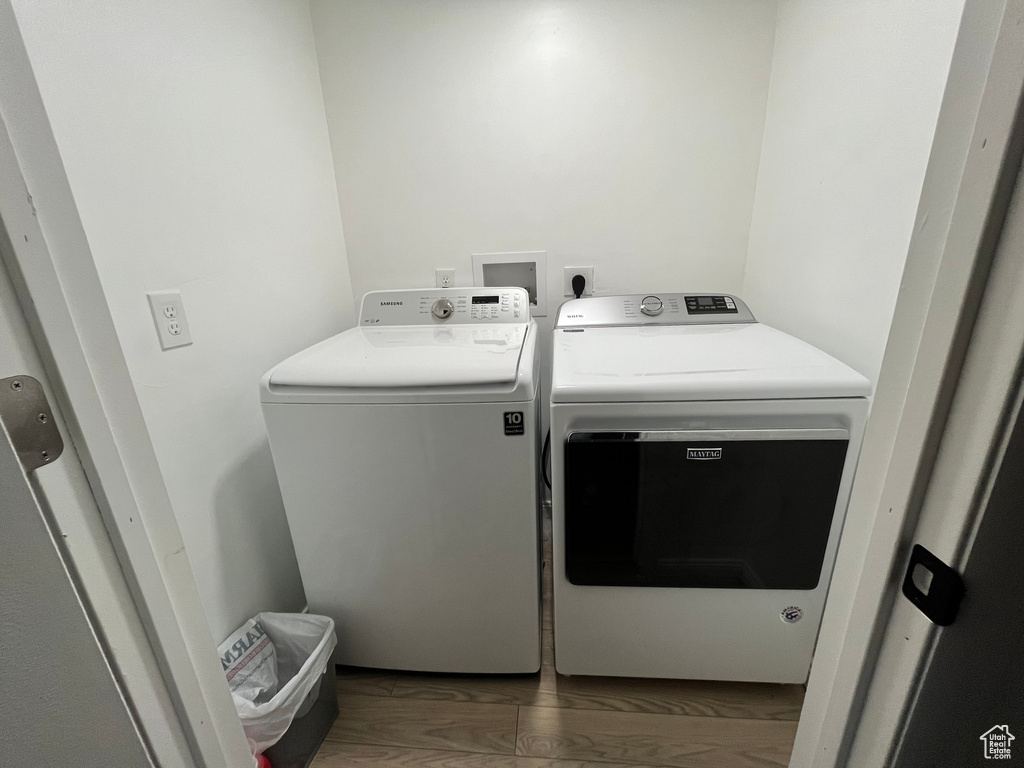 Laundry area with washer and dryer and dark hardwood / wood-style flooring