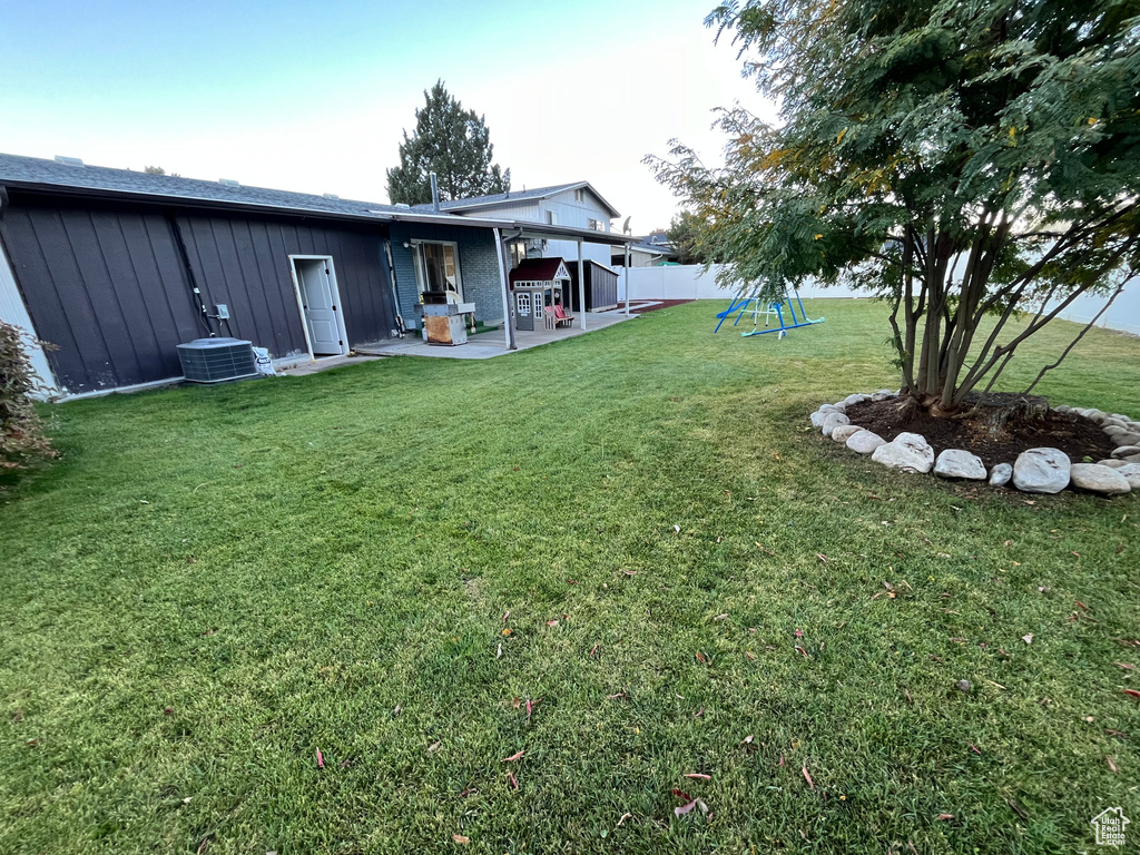 View of yard with central air condition unit and a patio area