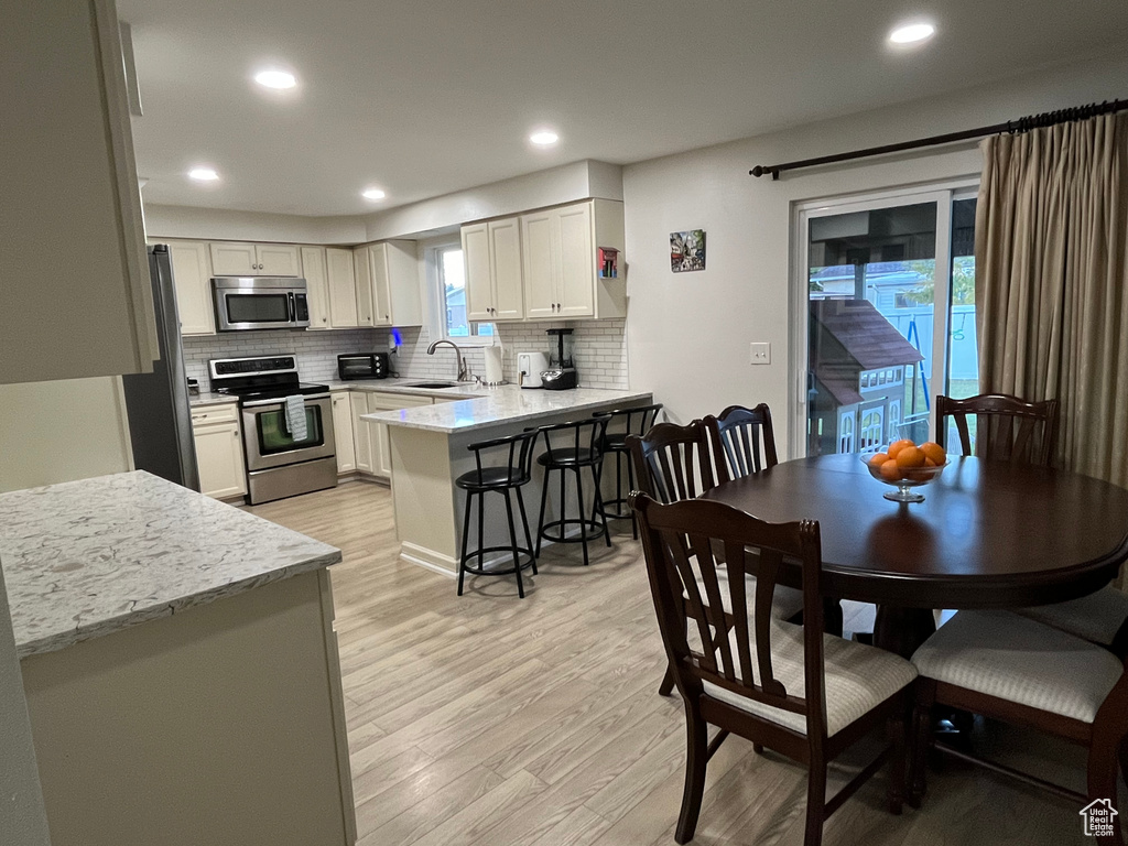 Dining space featuring sink and light wood-type flooring