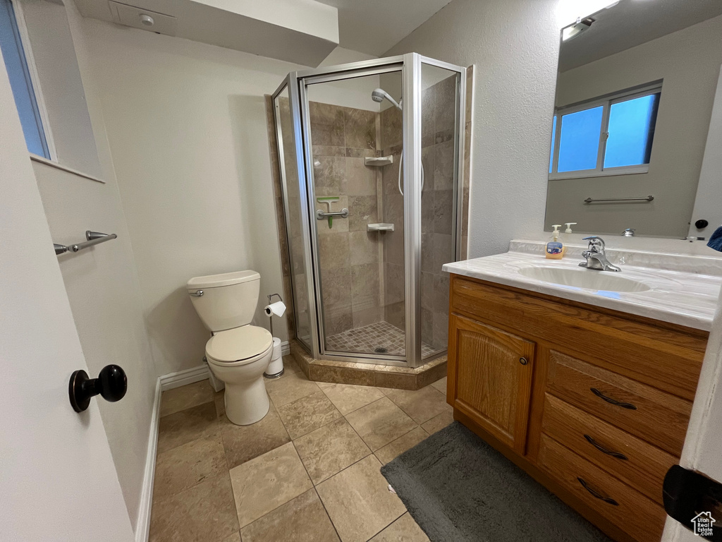 Bathroom featuring vanity, toilet, and a shower with shower door