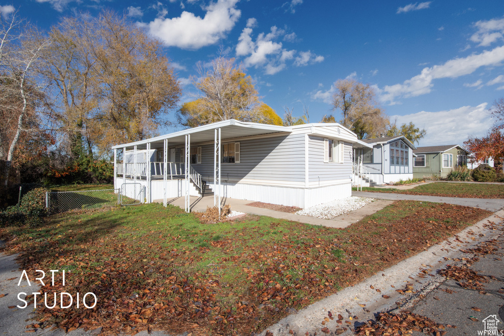 Manufactured / mobile home featuring a porch and a front lawn