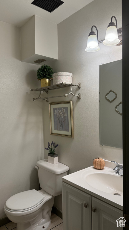 Bathroom with vanity, toilet, and tile patterned flooring