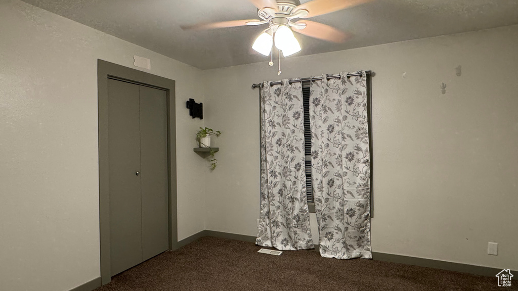 Carpeted spare room with ceiling fan