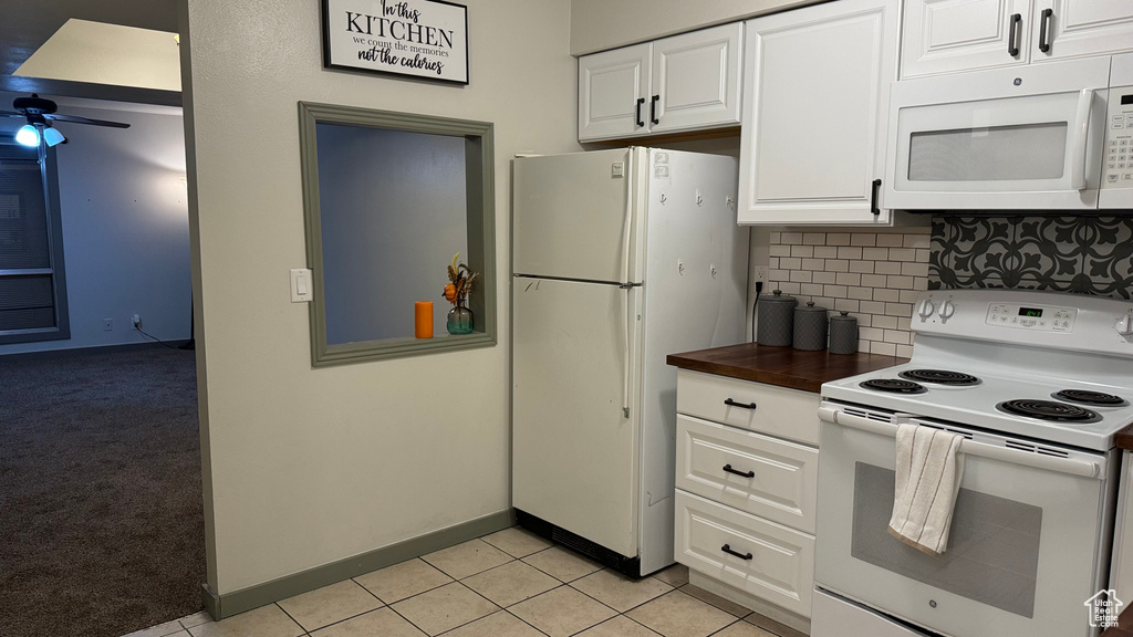 Kitchen with white cabinets, tasteful backsplash, ceiling fan, light tile patterned floors, and white appliances