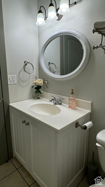 Bathroom featuring toilet, vanity, and tile patterned floors