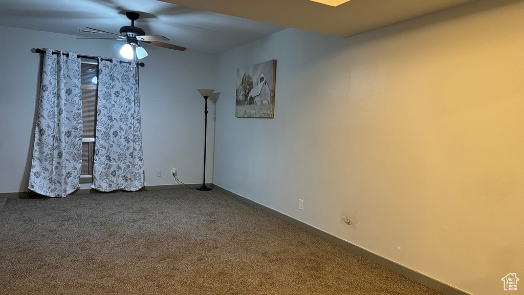 Carpeted empty room with ceiling fan