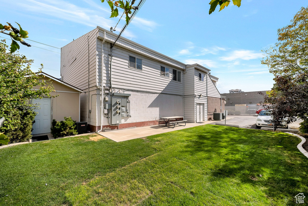 Rear view of house featuring central AC, a yard, and a patio
