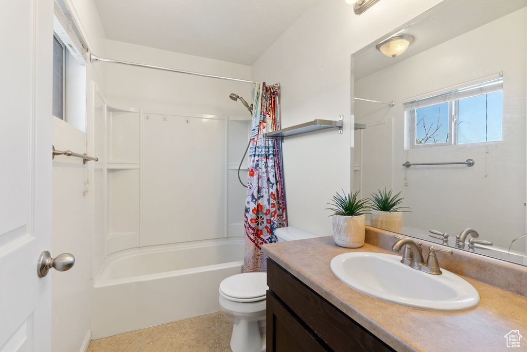 Full bathroom featuring vanity, toilet, and shower / bathtub combination with curtain