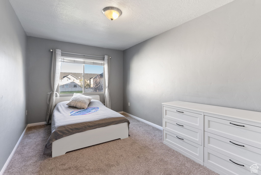 Carpeted bedroom with a textured ceiling