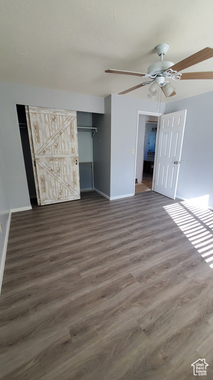 Unfurnished bedroom with dark wood-type flooring and ceiling fan