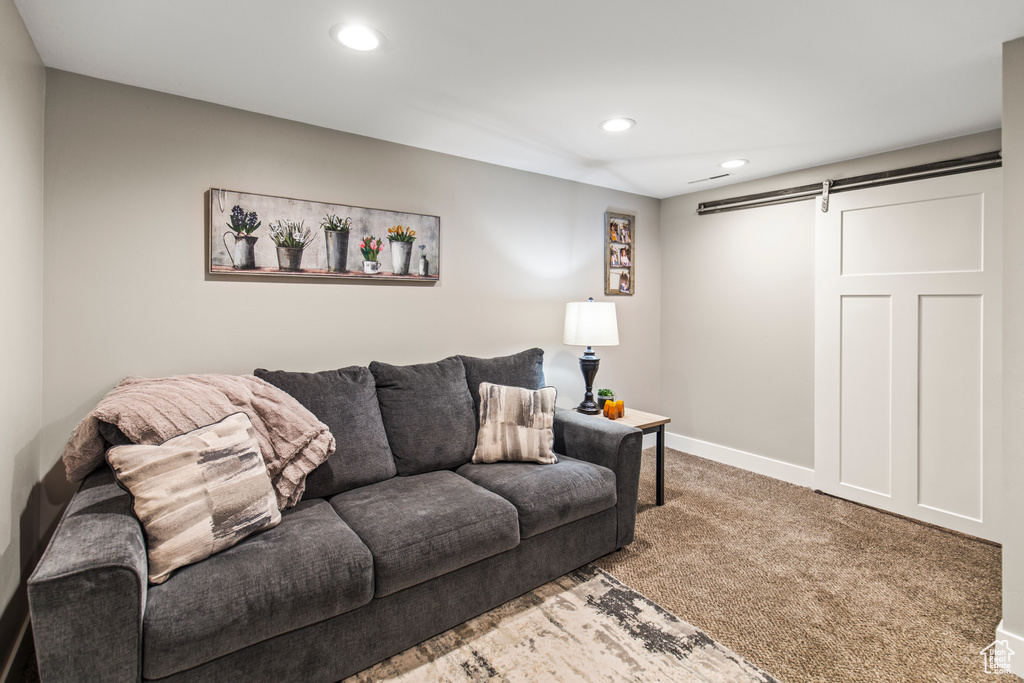 Carpeted living room featuring a barn door