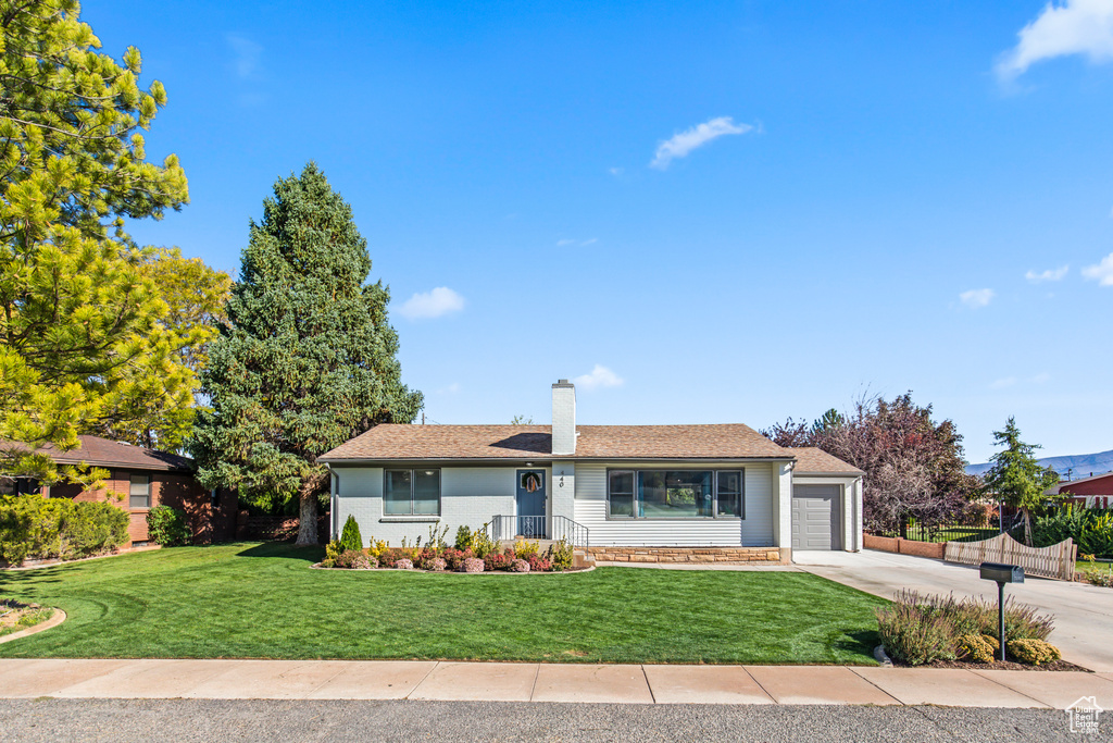 Ranch-style house featuring a front lawn and a garage