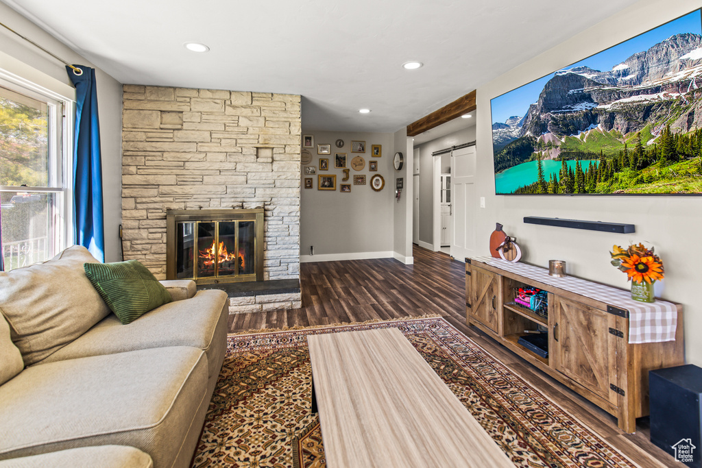 Living room featuring dark hardwood / wood-style floors, a fireplace, and a barn door