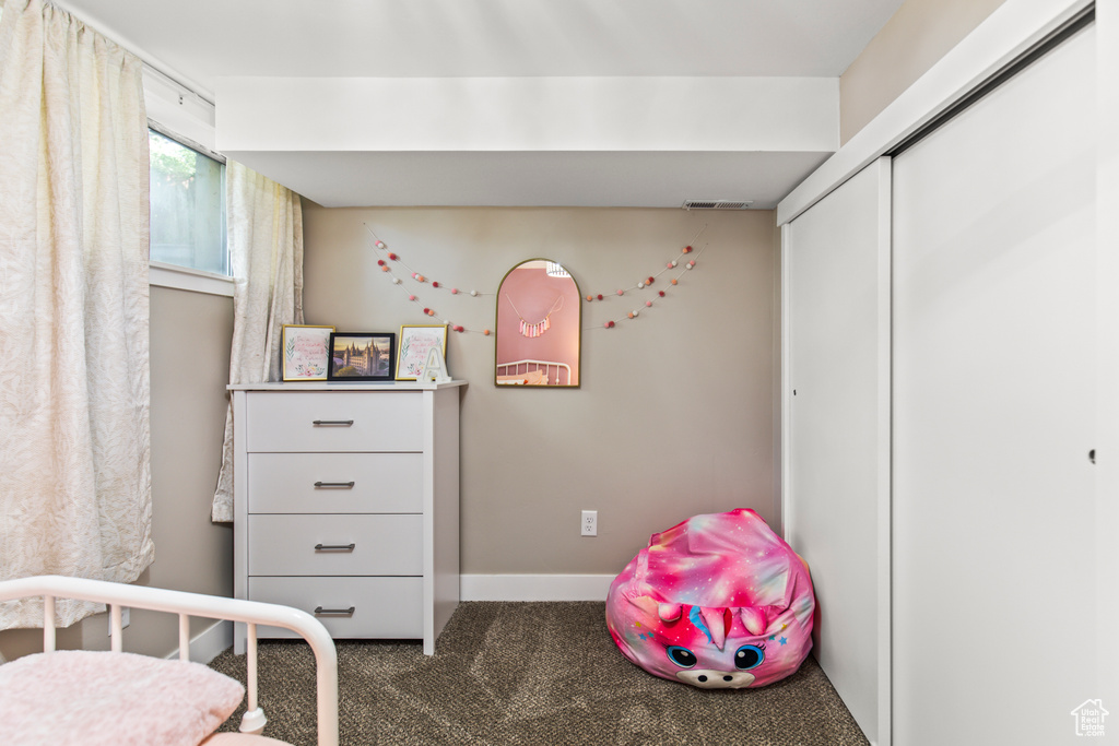 Bedroom with a closet and dark carpet