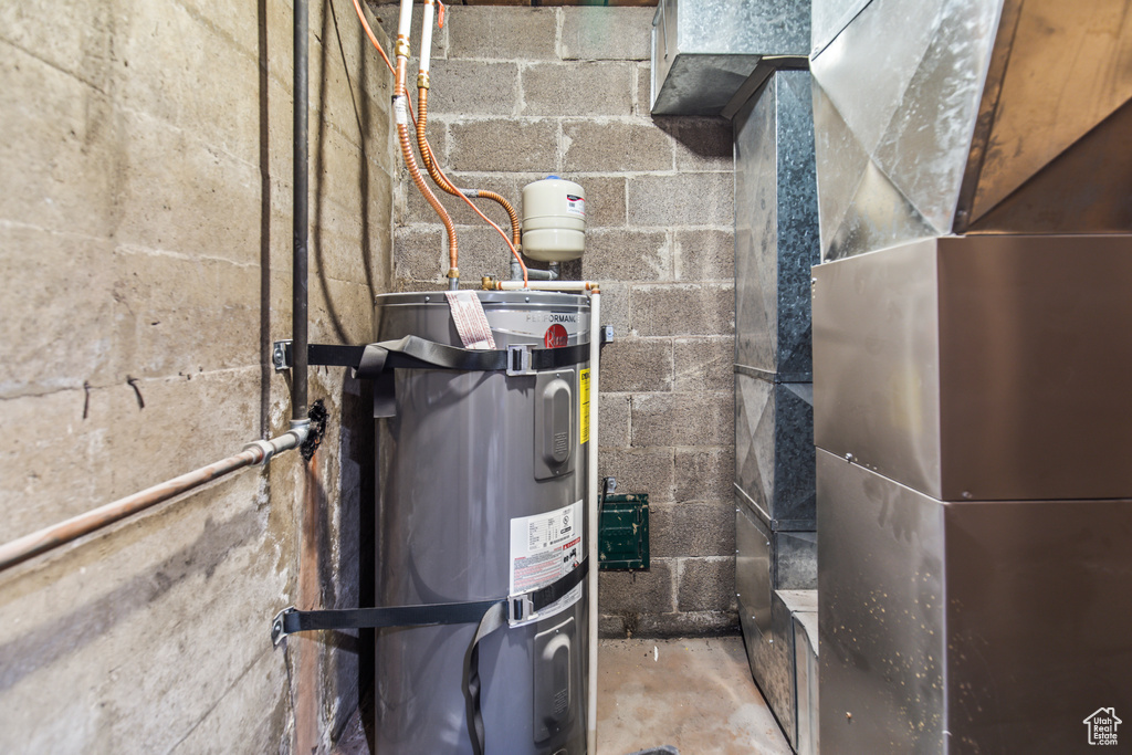 Utility room featuring water heater and heating unit