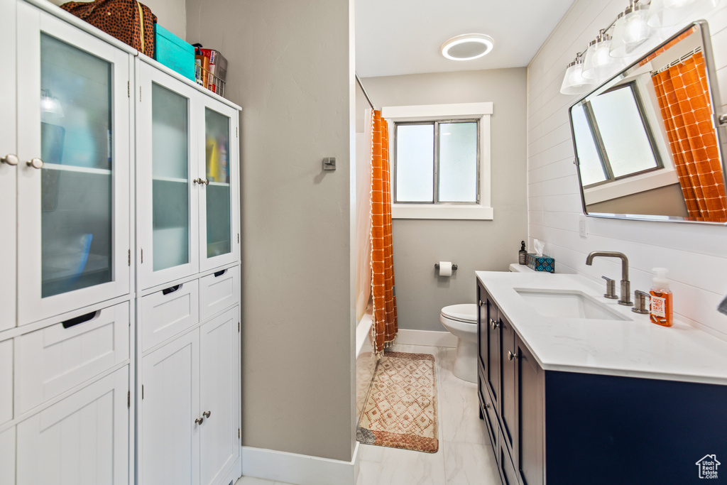 Bathroom with toilet, a shower with curtain, and vanity