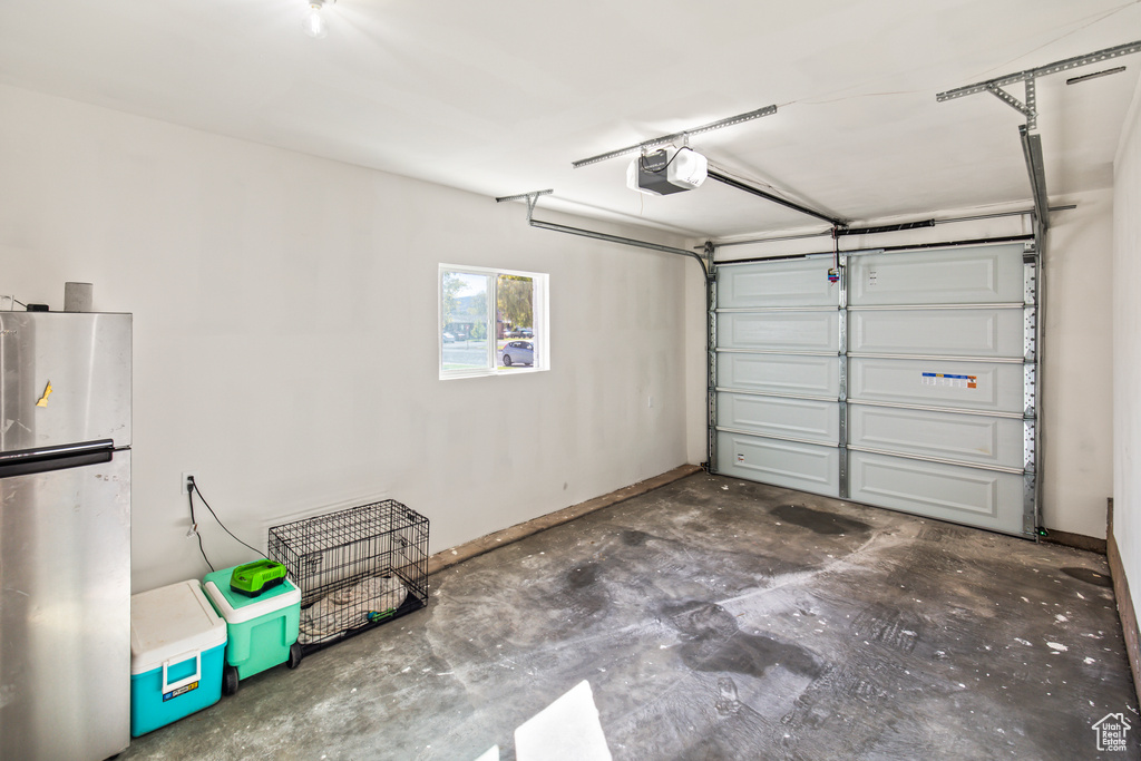 Garage with a garage door opener and stainless steel refrigerator