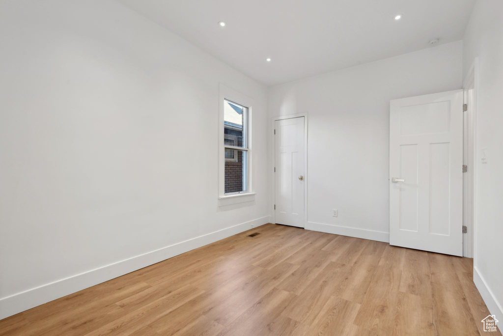 Empty room with light hardwood / wood-style floors