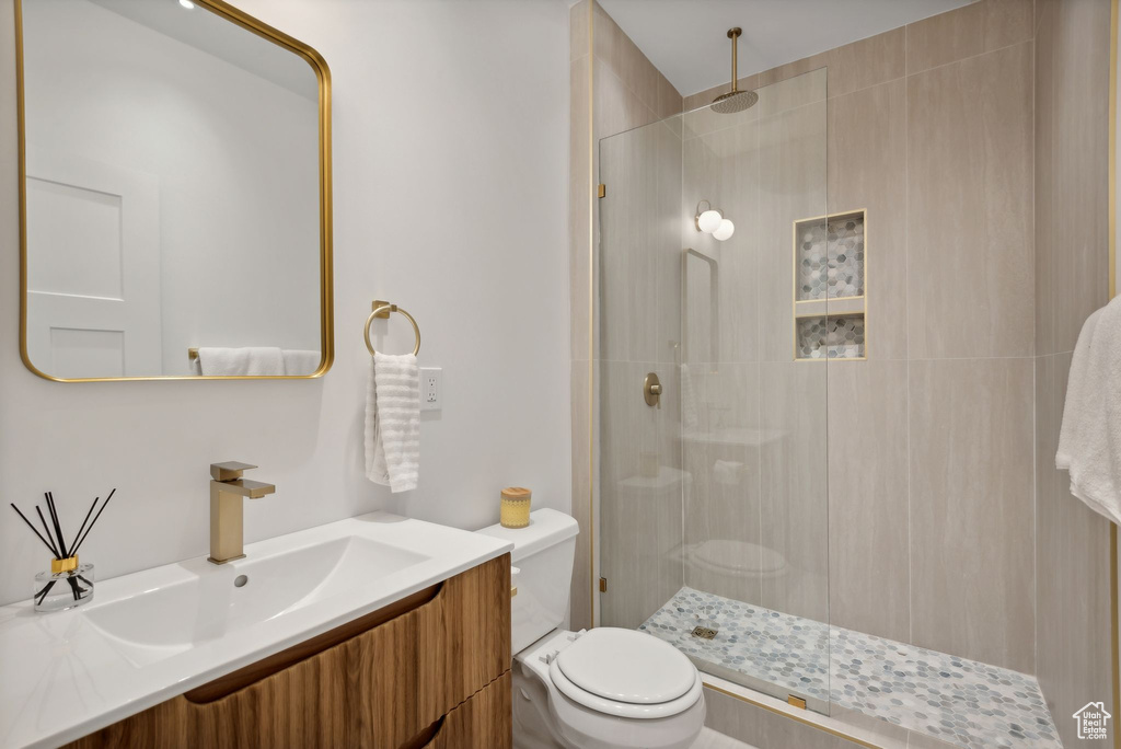 Bathroom with vanity, toilet, and an enclosed shower