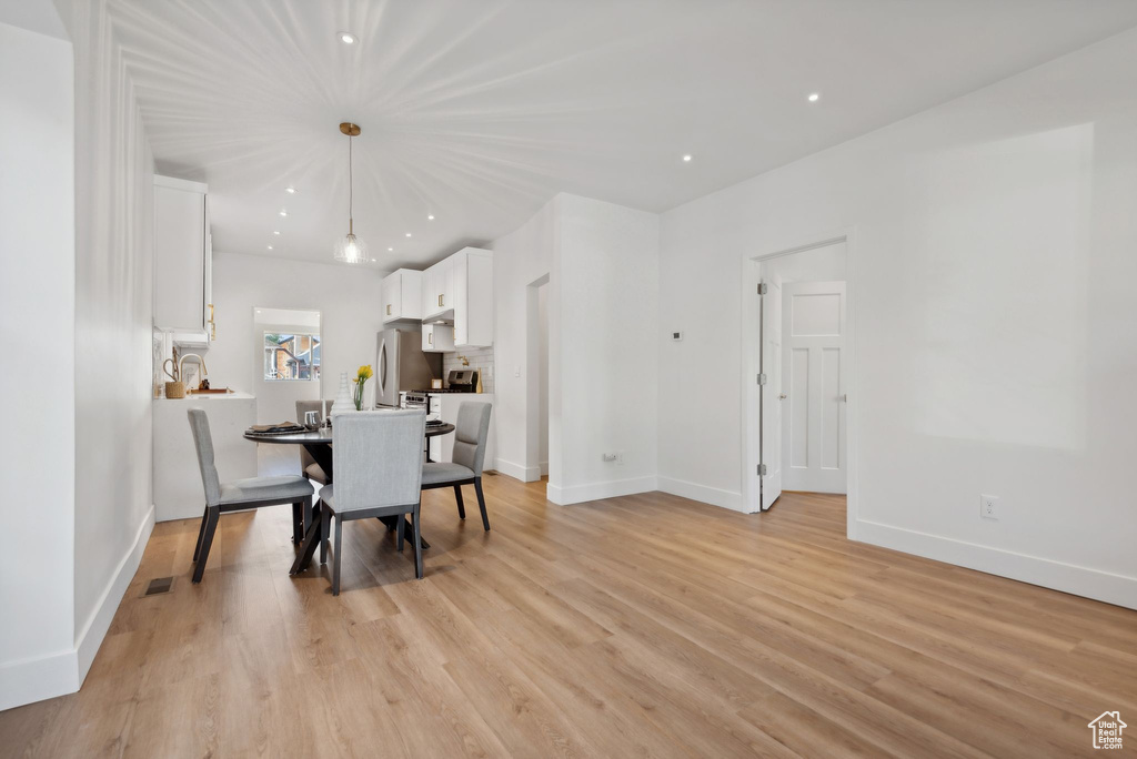 Dining area with light hardwood / wood-style flooring