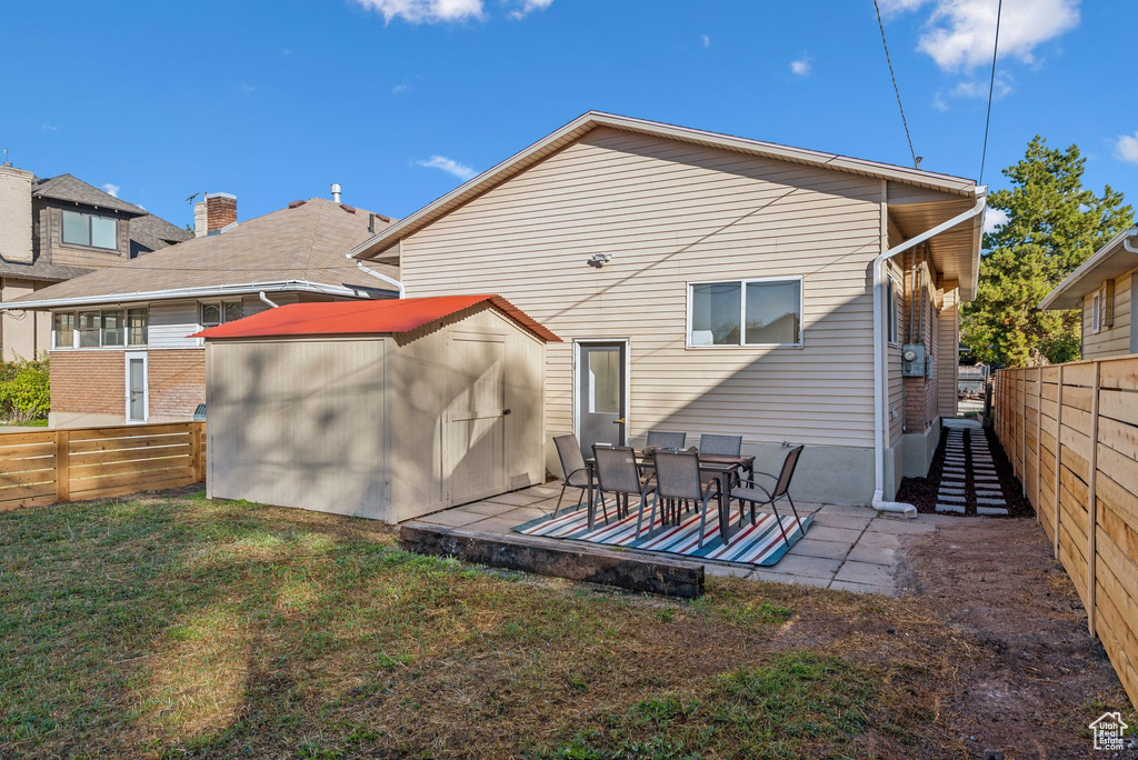 Rear view of house with a patio area and a lawn