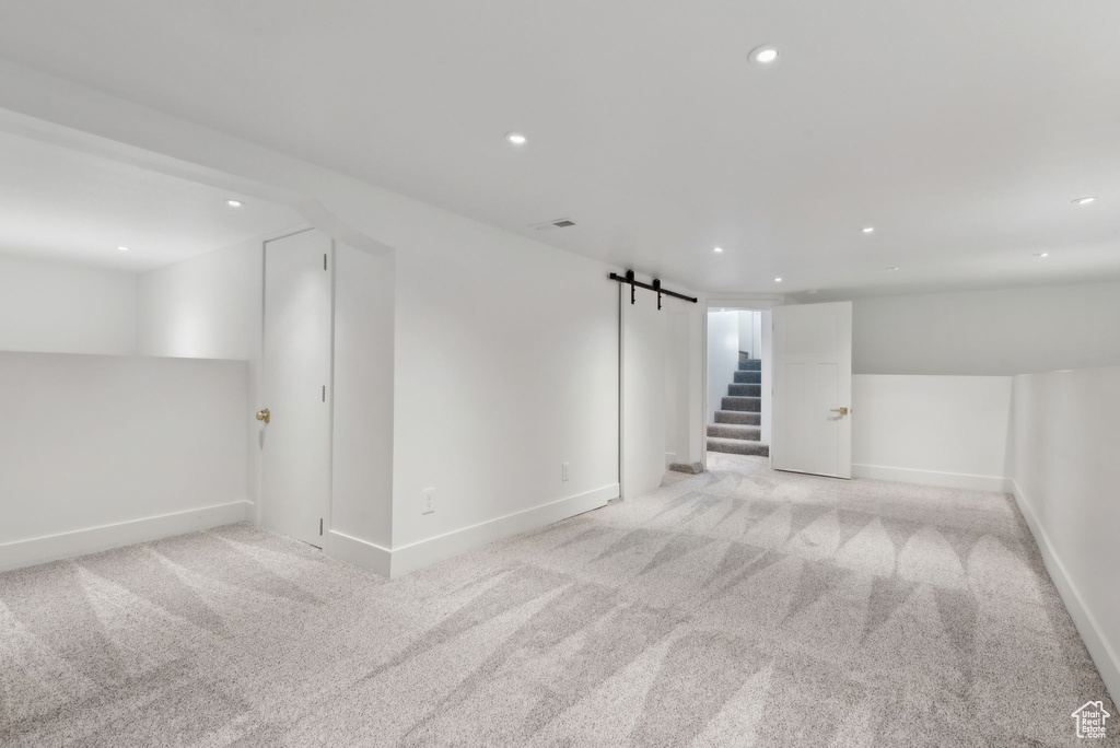 Interior space featuring a barn door and light colored carpet