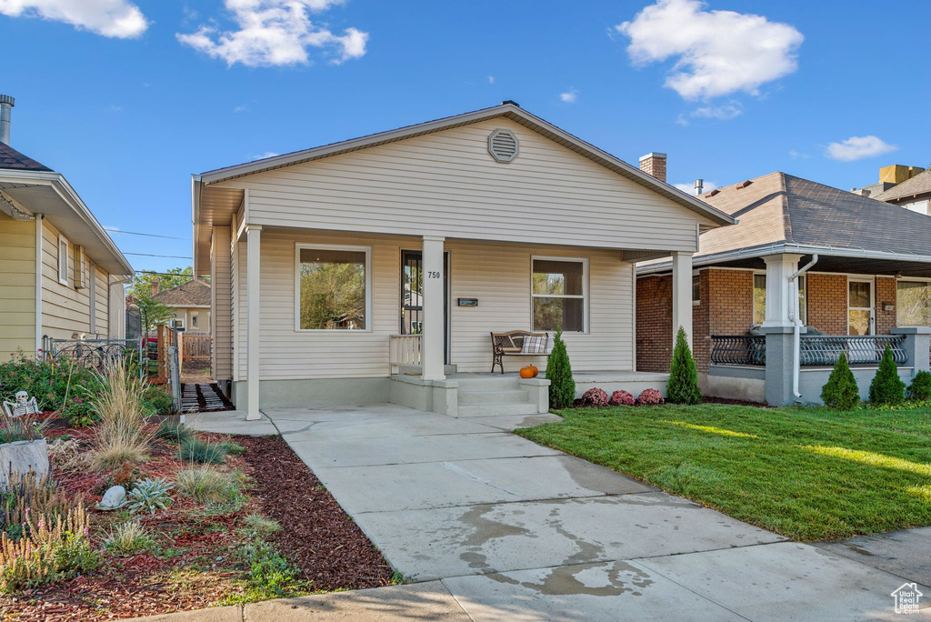 Bungalow-style house with a front yard and covered porch