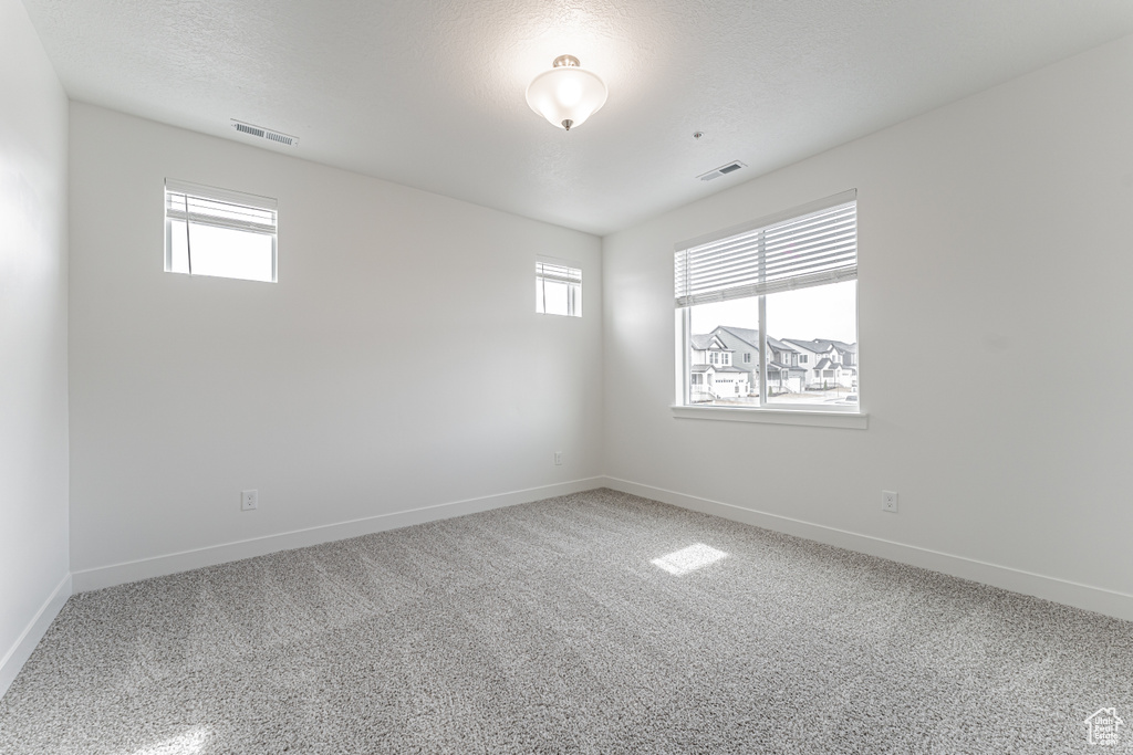 Carpeted empty room featuring baseboards