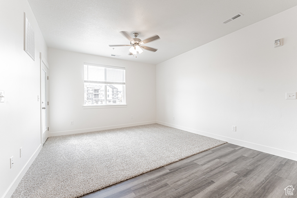 Empty room with ceiling fan, baseboards, and wood finished floors