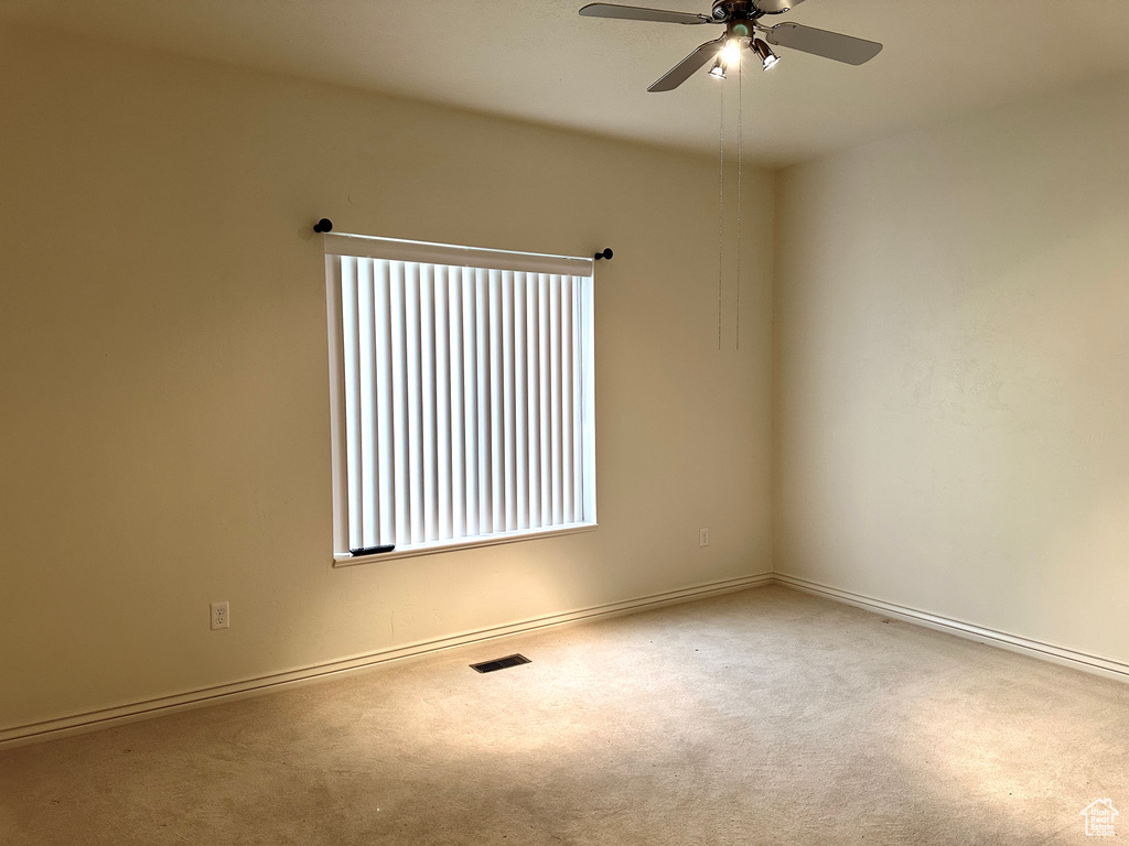 Spare room featuring ceiling fan, a healthy amount of sunlight, and carpet