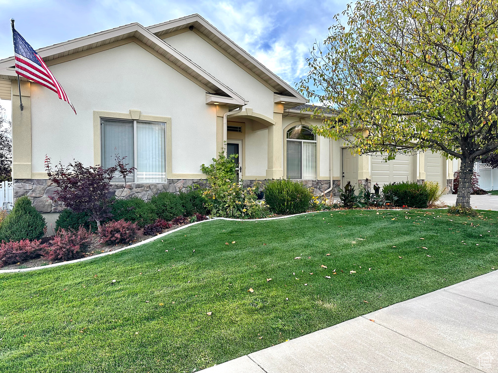 View of front of property featuring a front yard and a garage