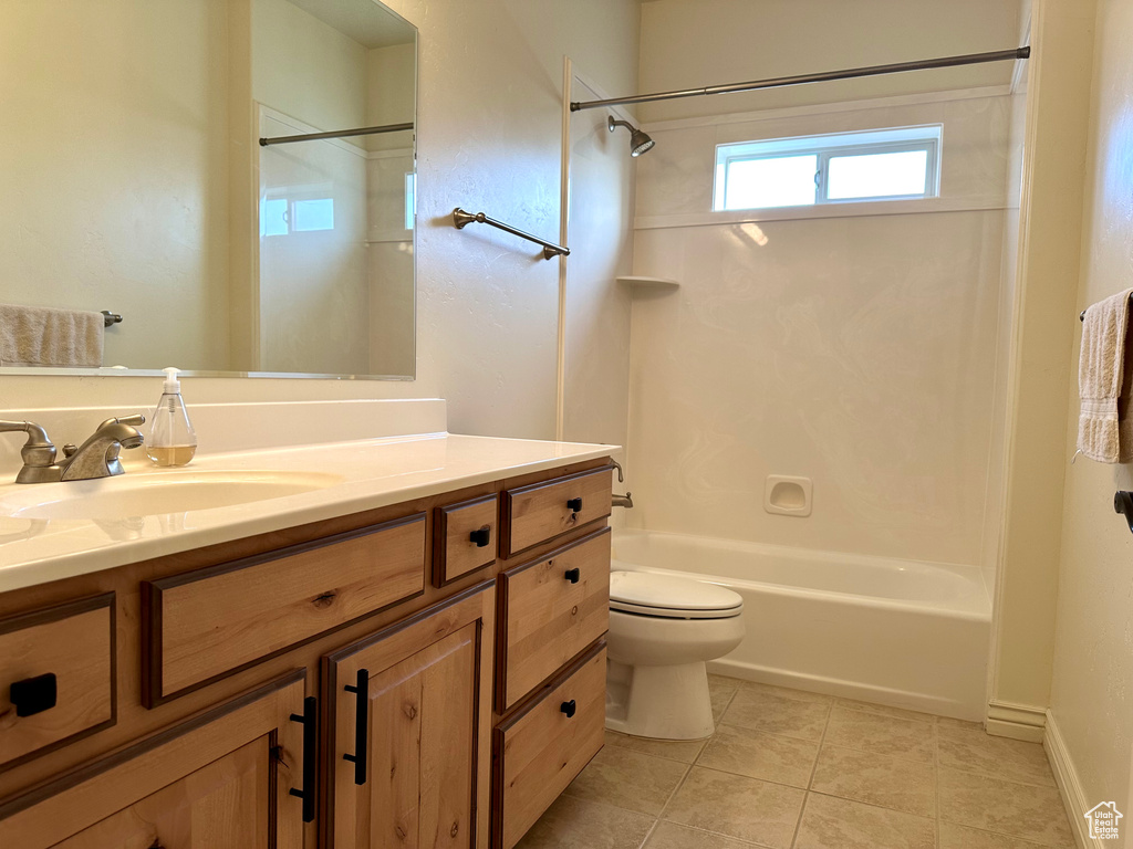 Full bathroom with vanity, toilet, tile patterned floors, and shower / tub combination