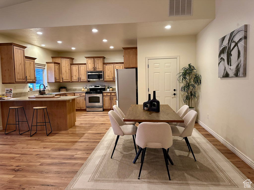 Dining space featuring sink and light wood-type flooring