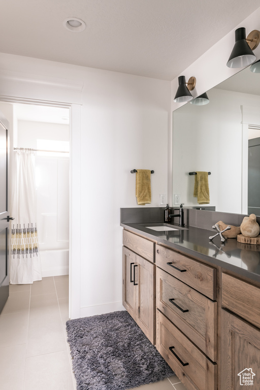 Bathroom featuring tile patterned flooring, shower / bath combo, and vanity