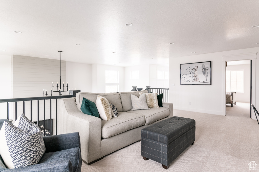 Carpeted living room with plenty of natural light and a chandelier