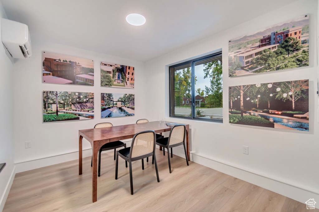 Dining room with an AC wall unit and hardwood / wood-style floors