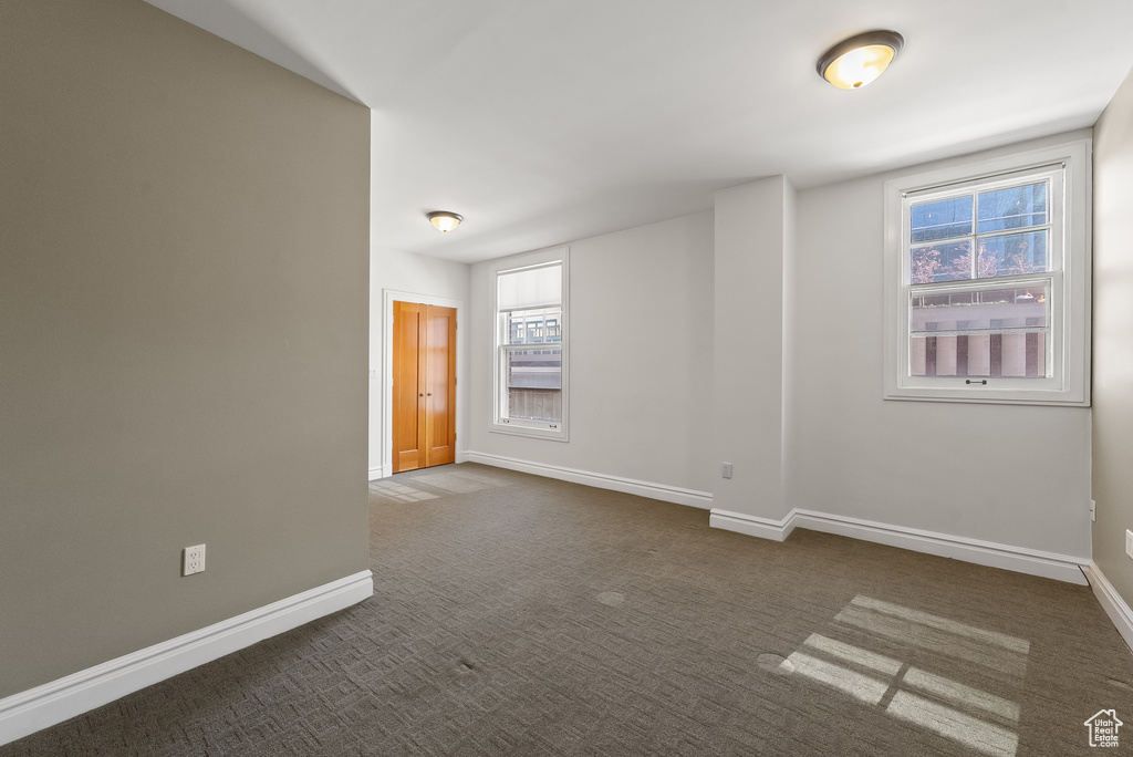 Spare room featuring dark carpet