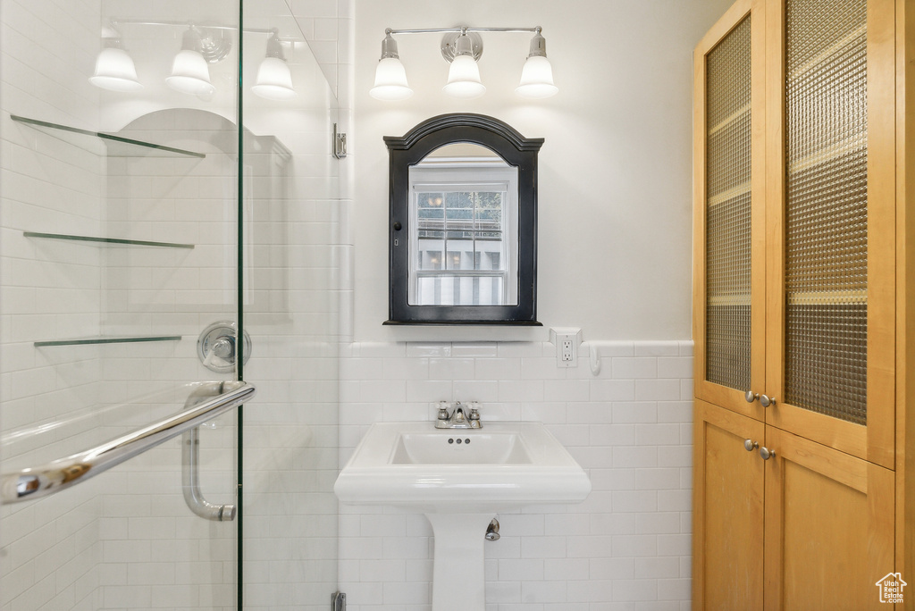 Bathroom with tile walls and a shower with shower door