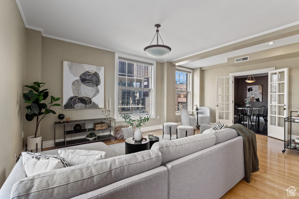 Living room with crown molding, hardwood / wood-style flooring, and french doors